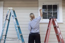 Woman painting outdoor window
