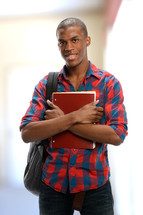 A student with a book bag and notebook.
