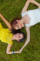 adult sisters lying on the grass