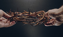 hands holding a crown of thorns 