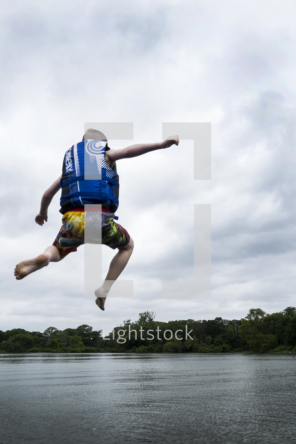 child jumping into a lake