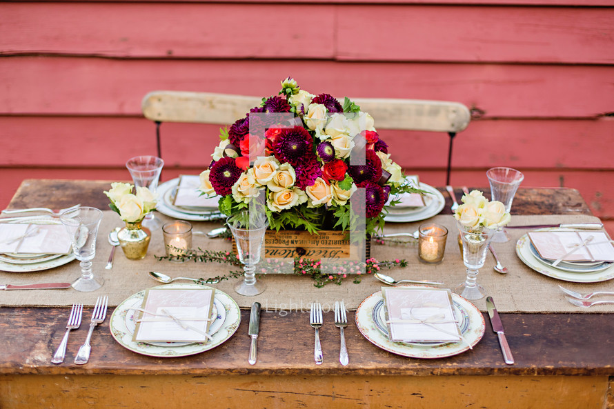 An outside table setting wedding country rustic chic plates forks spoons candles florals