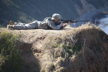 Soldier on hill aiming gun