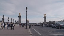 Paris, France - March 20, 2024: The Pont Alexandre III bridge and its main golden Pegasus pillar towering in the background of the Hôtel des Invalides, Paris.