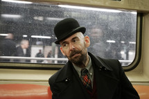 a man on a train with a top hat and mustache 