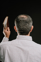 man preaching holding a bIble 