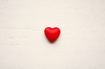 a red heart on white wood background 