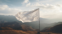 White surrender flag blowing in the wind on a mountain.