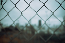 Chain linked fence in a city | Bokeh | Cinematic | World | Day | Cloudy | Sky | Town | Restricted | Youth