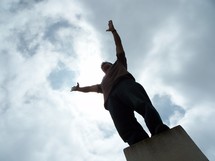man standing with arms raised in worship to God