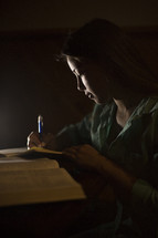 a teen girl writing after reading in the Bible