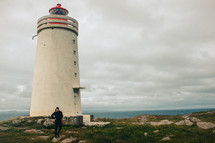 a man walking beside a lighthouse 