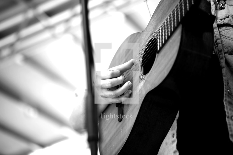 hand playing an acoustic guitar