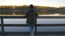a woman looking over a railing on a dock 