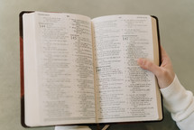 a person holding up an open Bible 