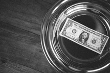 single dollar in an offering plate