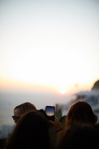 tourists taking pictures at sunset in Greece 