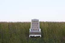 empty chair in a field of tall grass