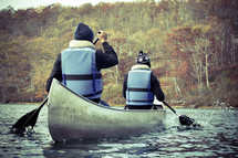 men paddling a canoe in fall 