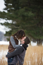 couple kissing in a field 