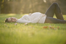 pregnant woman lying in the grass