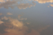 reflection of clouds at sunset on water 