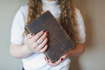 a young woman holding old Bible