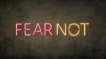 The words "fear not" in neon on a grunge wall. 

2 Timothy 1:7