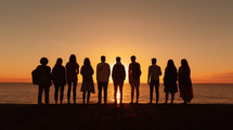 Silhouette of friends at sunset on the beach. 