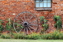 wagon wheel against a brick wall 