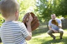 father and son throwing a baseball together.