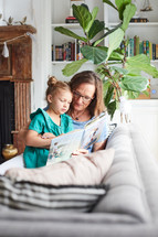 a grandmother reading a book to her granddaughter 