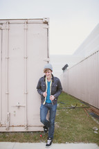 man in hat and jacket standing in front of a storage locker