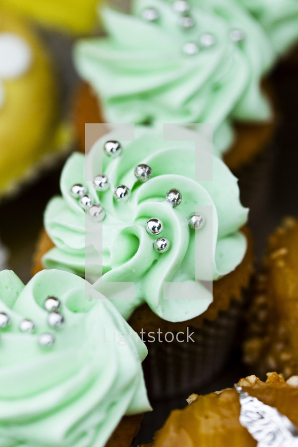 Chocolate cupcakes with green frosting and silver beads