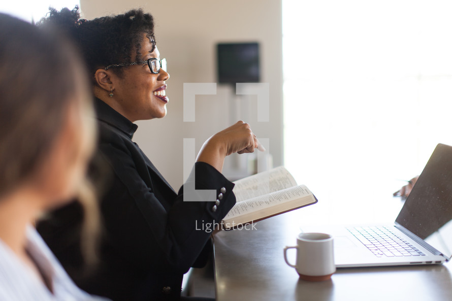 woman reading a Bible at a business meeting in a conference room 