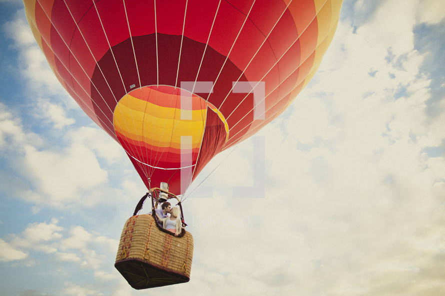 A couple kissing in a colorful hot air balloon - take you love to new heights