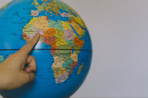 finger pointing to a globe 