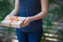 a woman holding a wrapped gift 