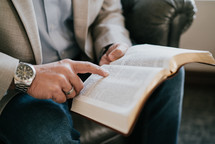 a man sitting reading a Bible 