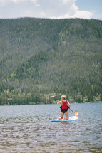 a woman on a paddle board in the ocean 