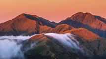 Beautiful evening sunset over misty alpine mountains in wild New Zealand landscape of Tararua Mountain Range Nature outdoor Time lapse
