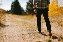 a man walking down a dirt road 