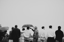 tourists standing under umbrellas 