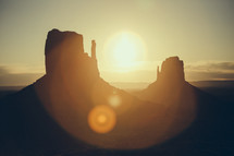 sunburst and desert rock formation peaks 