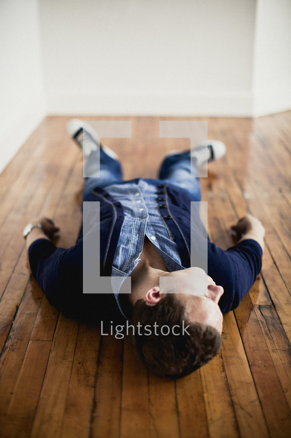 man lying on a wood floor