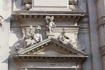 statues in stone on over a doorway 
