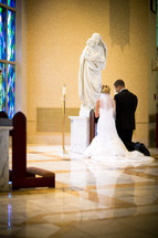 bride and groom - kneeling at altar, prayer - church interior