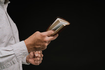 a man preaching holding a Bible 