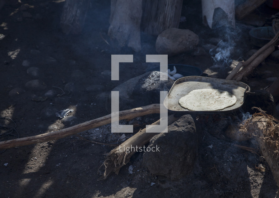 Baking flatbread on an outside wood pit.