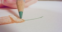 Macro shot of a colored pencil tip drawing on paper.